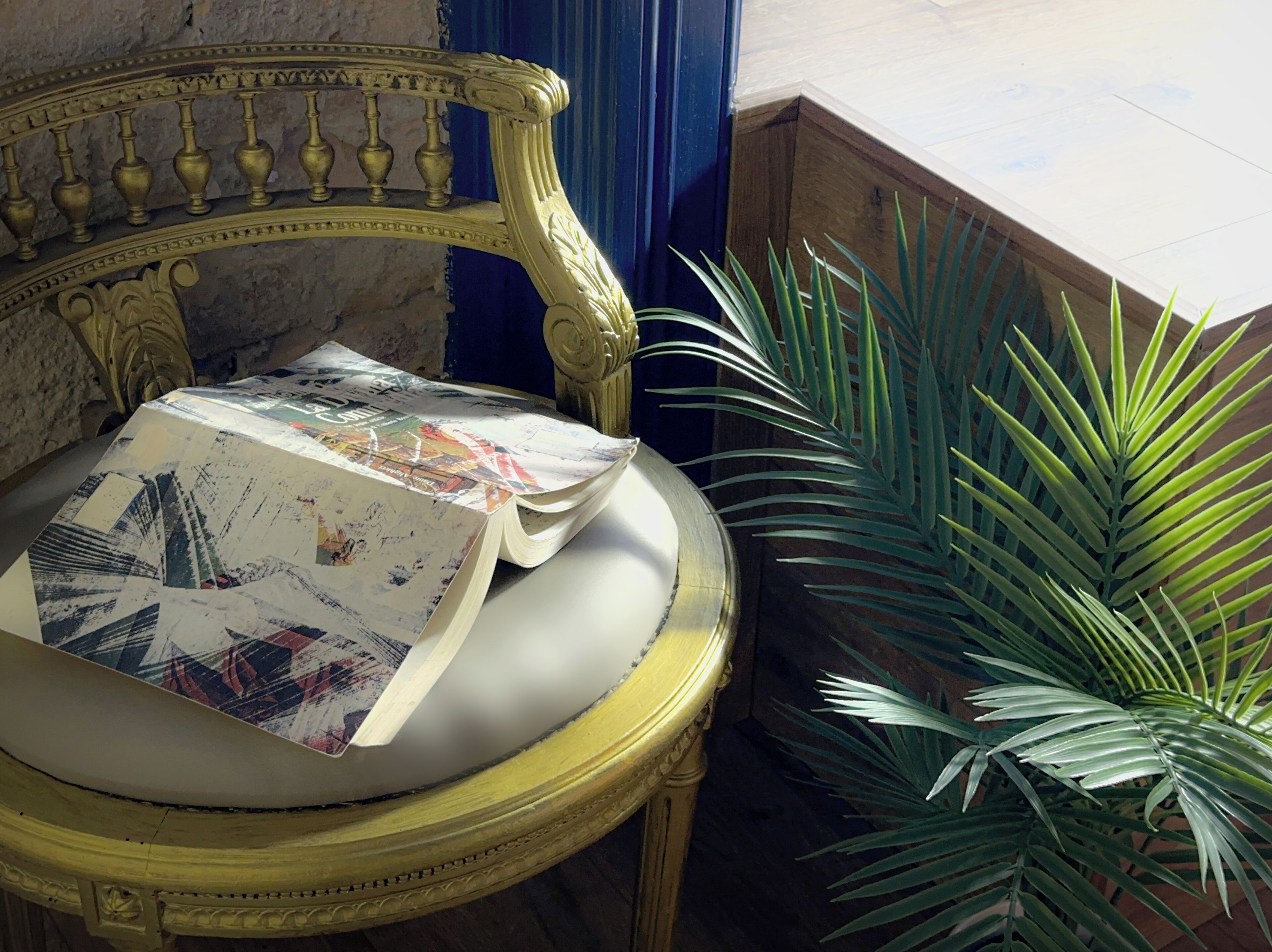 A room with a decorative bench, a potted plant, and a partially open book.