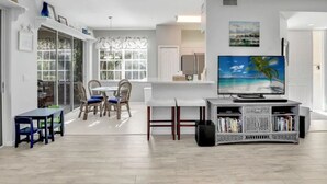 Ein modernes Wohnzimmer mit Essbereich, Fernseher und Bücherregal.