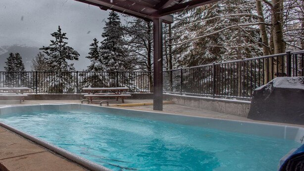 A pool area with a view of snow-covered trees and mountains. - Beautiful Ski-in/Ski out Center Village studio, sleeps 4 (Copper Mountain)