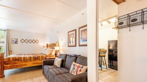 A cozy room with a bed, a sofa, and a dining area. - Beautiful Ski-in/Ski out Center Village studio, sleeps 4 (Copper Mountain)