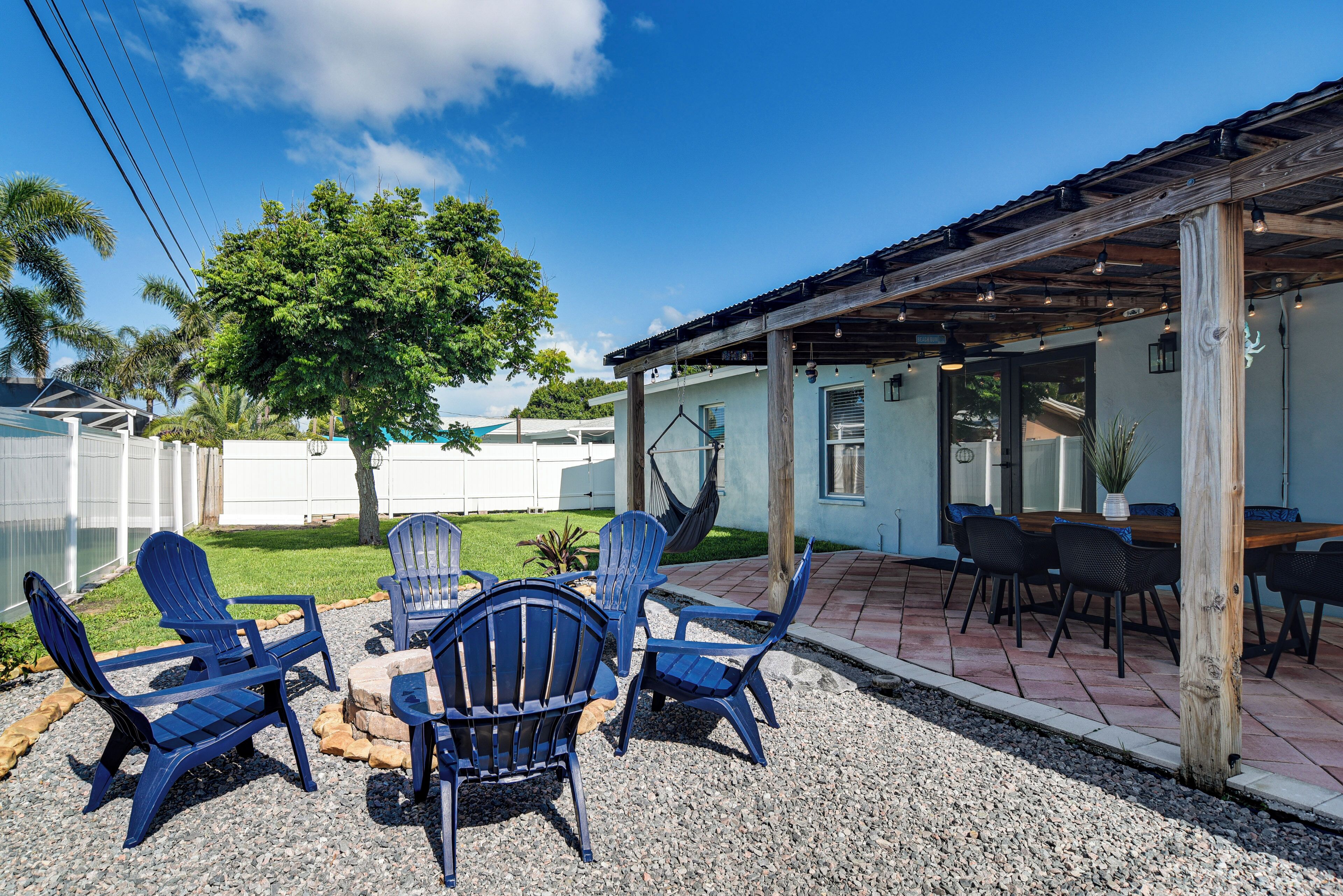 Un espacio de estar al aire libre con sillas Adirondack y un pérgola de madera.