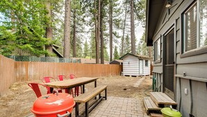 A backyard with a wooden table, red chairs, a red grill, and a green grill. - Work & Play! Lake Tahoe Cabin 5 Mi to Heavenly Mtn (South Lake Tahoe)