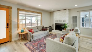 A spacious living room with a fireplace, a large window, and a cozy seating area. - Work & Play! Lake Tahoe Cabin 5 Mi to Heavenly Mtn (South Lake Tahoe)