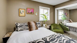 A bedroom with a bed, a green armchair, a potted plant, and two framed pictures on the wall. - Work & Play! Lake Tahoe Cabin 5 Mi to Heavenly Mtn (South Lake Tahoe)