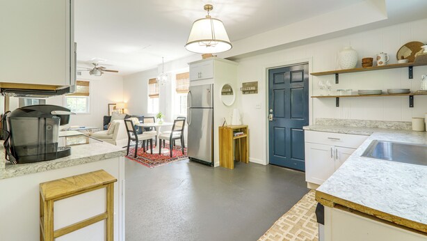 A modern kitchen with a coffee maker, refrigerator, and dining area.