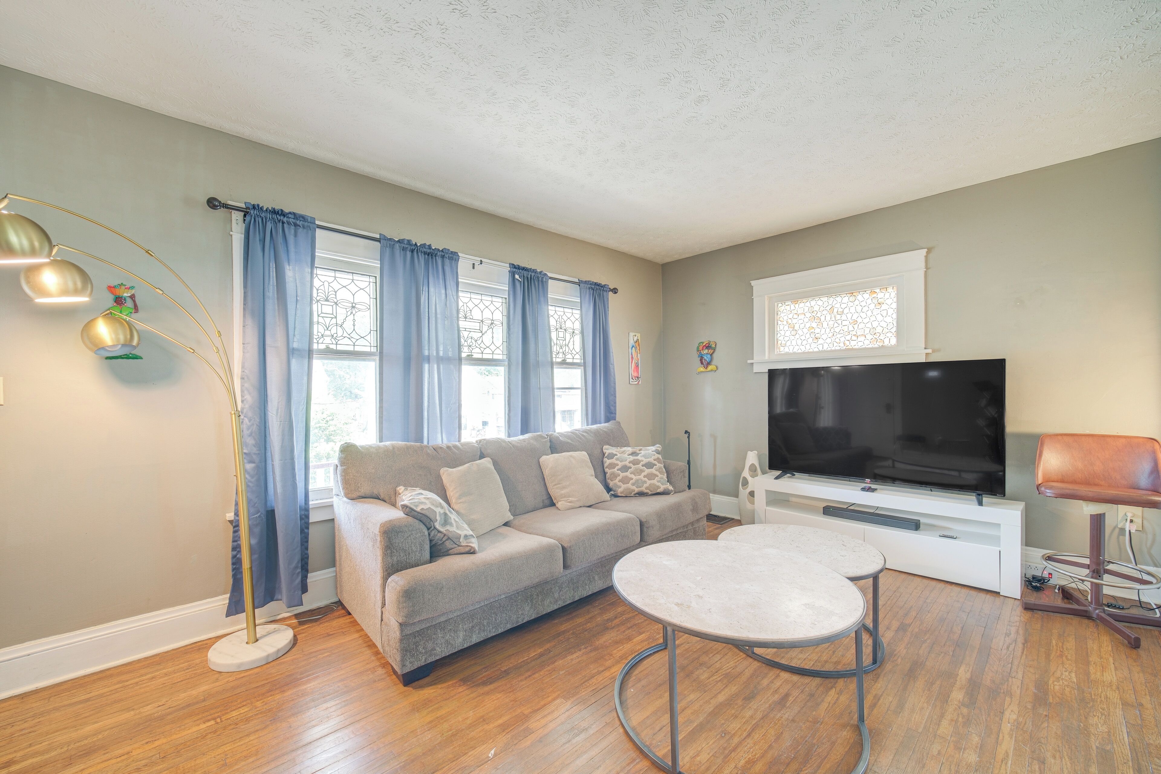A living room with a sofa, a coffee table, a TV, and a floor lamp.