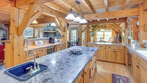 A spacious kitchen with wooden cabinets, a granite countertop, and a large island with a sink. - Steps From Natl Forest: Creekside Home in Durango (Durango)