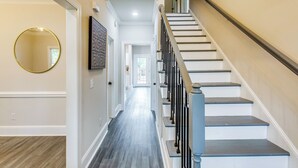 A hallway with a staircase leading to a second floor. - 3-story Home w/ Private Backyard in Florence! (Florence)