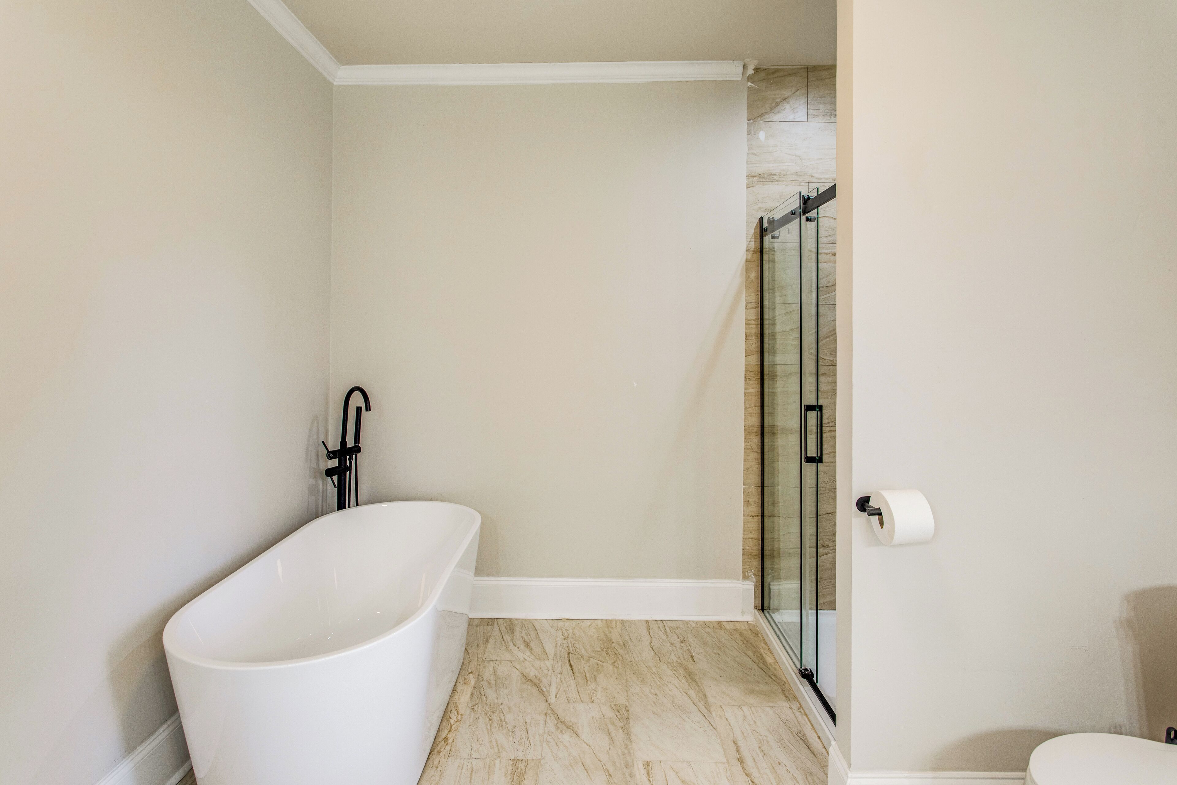 A bathroom with a freestanding bathtub, a glass shower enclosure, and a toilet.