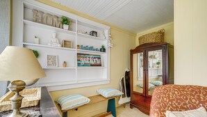 A cozy room with a bed, a bench, a lamp, a bookshelf, and a wardrobe. - 2 Mi to Hiking Trails: Cozy Fayetteville Cottage! (Fayetteville)