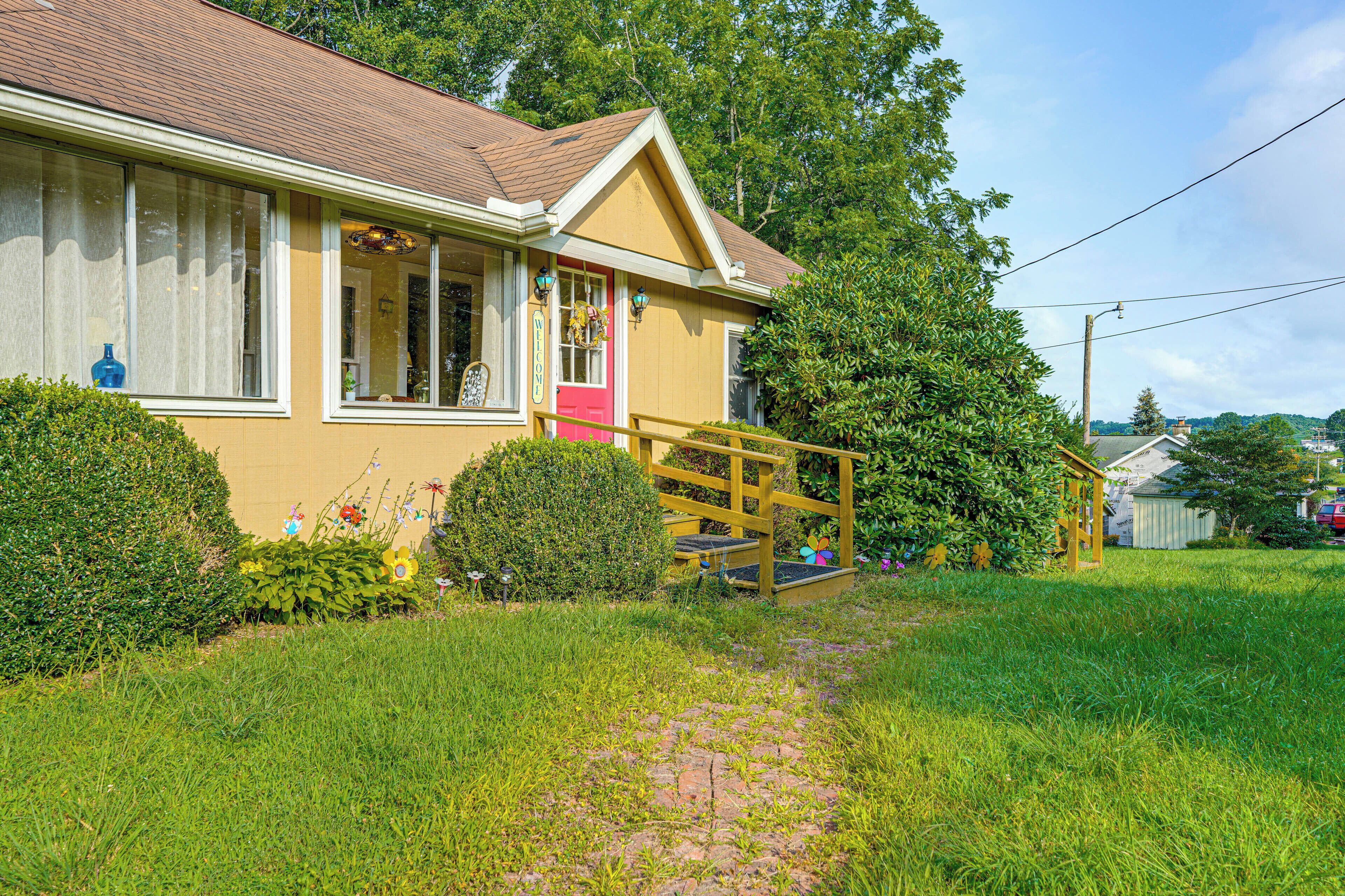 A house with a front porch, a small garden, and a pathway leading to the entrance.