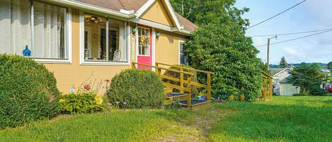 A house with a front porch, a small garden, and a pathway leading to the entrance.