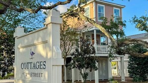 A sign for cottages at 2nd street, a house with a porch, and a tree in the foreground. - Walk to Beach: Cottage w/ Yard in Pass Christian! (Pass Christian)