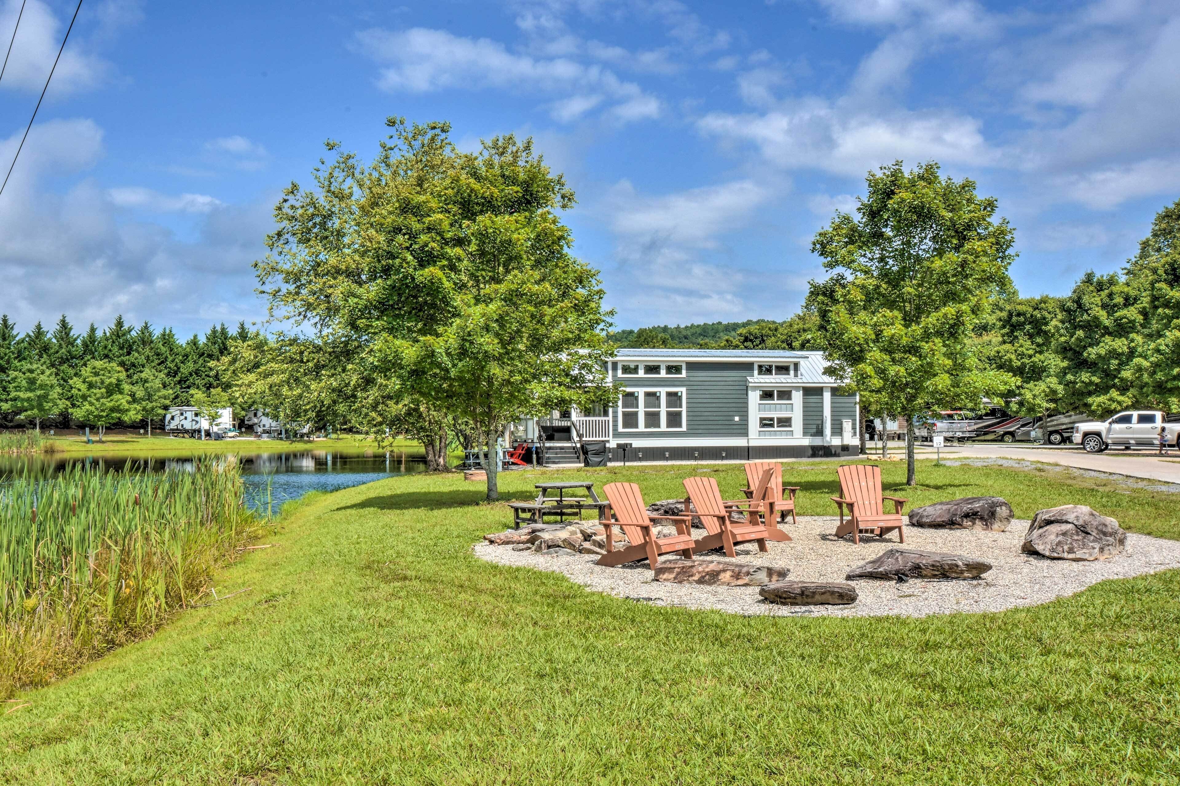 A lakeside cabin with a deck, outdoor seating, and a view of the lake.