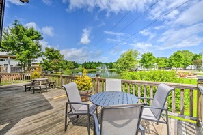 A wooden deck with outdoor furniture, a lake view, and a wooden fence. - 1 Mi to Tank Town Usa: Tiny Home w/ Pool Access! (Morganton)