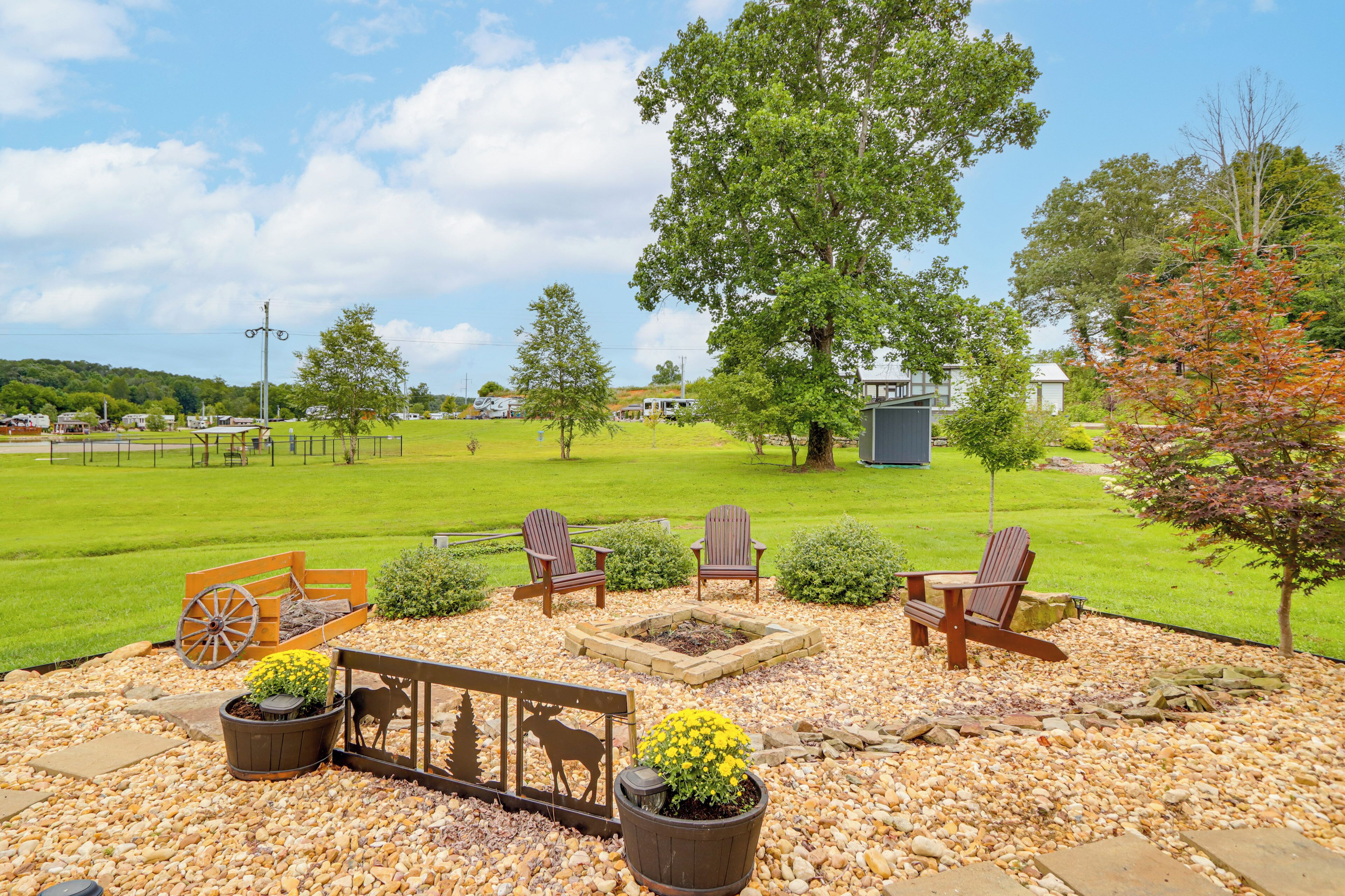 A patio with outdoor furniture, a fire pit, and a decorative metalwork piece.