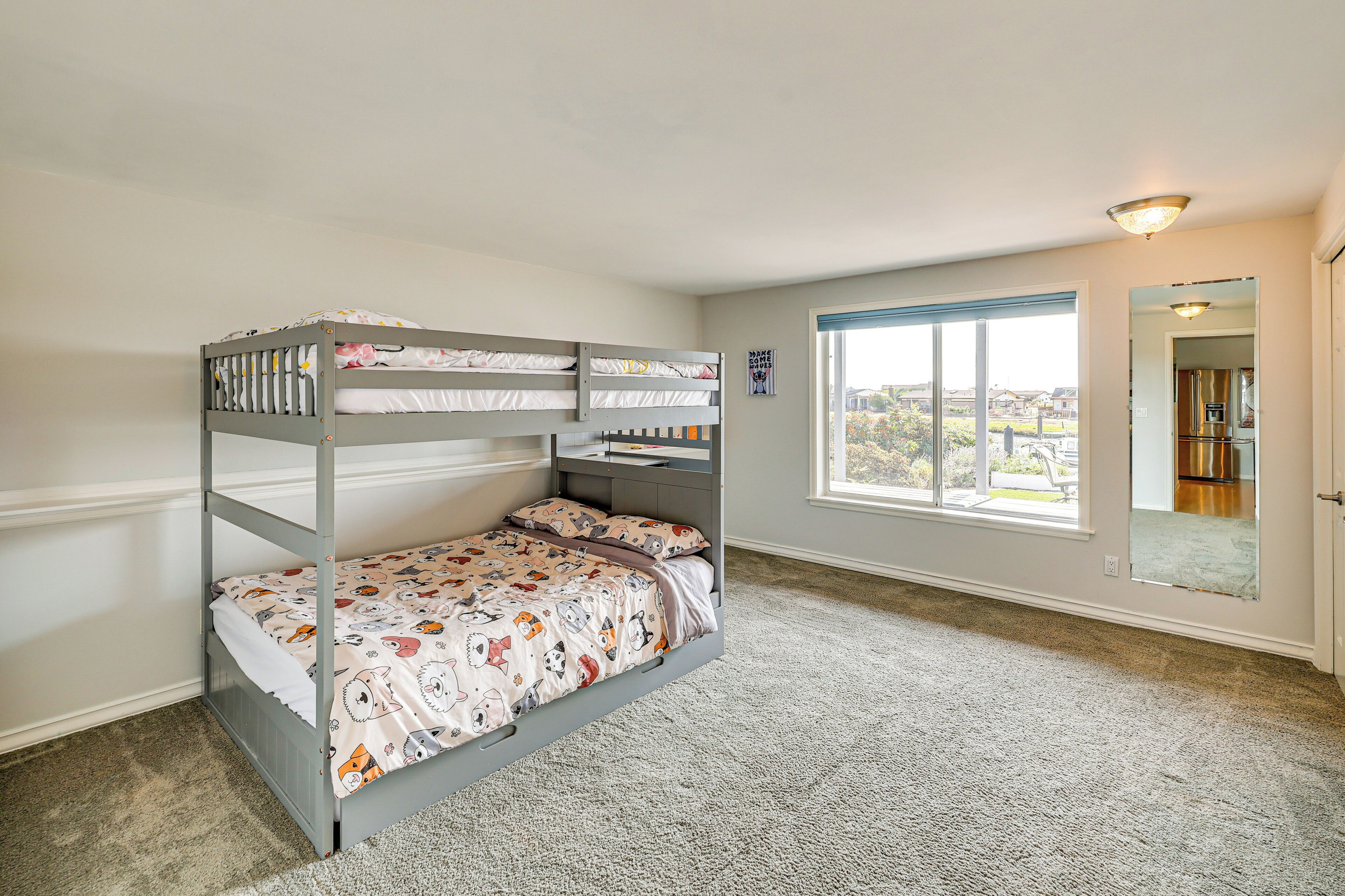 A bunk bed room with a view of the outside through a large window.