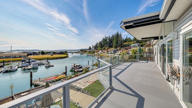 A balcony with a view of a marina, boats, and a river. - Waterfront Home w/ Dock, Hot Tub, Fire Pit (Oak Harbor)