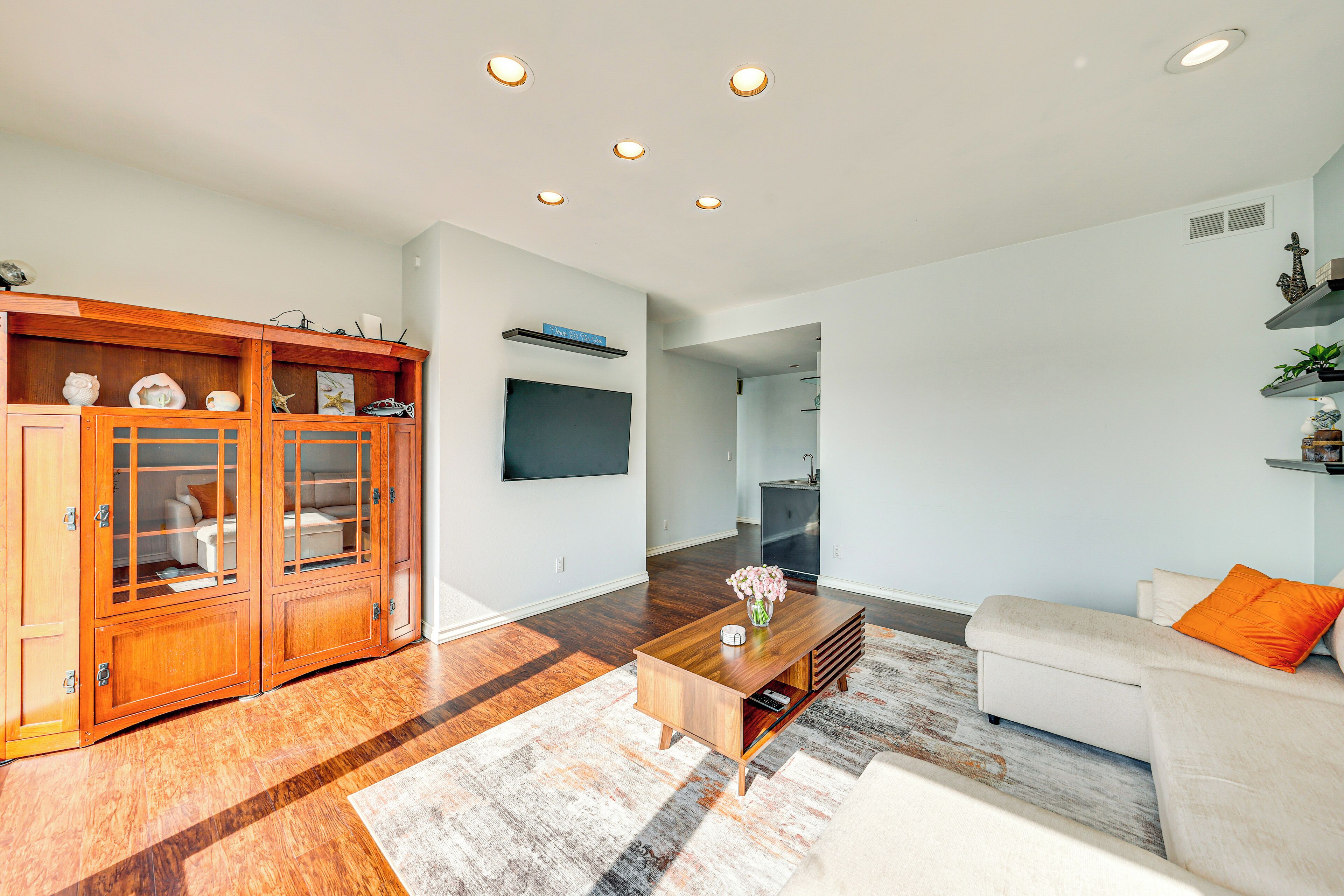 A modern living room with a wooden cabinet, a white sofa, and a coffee table.
