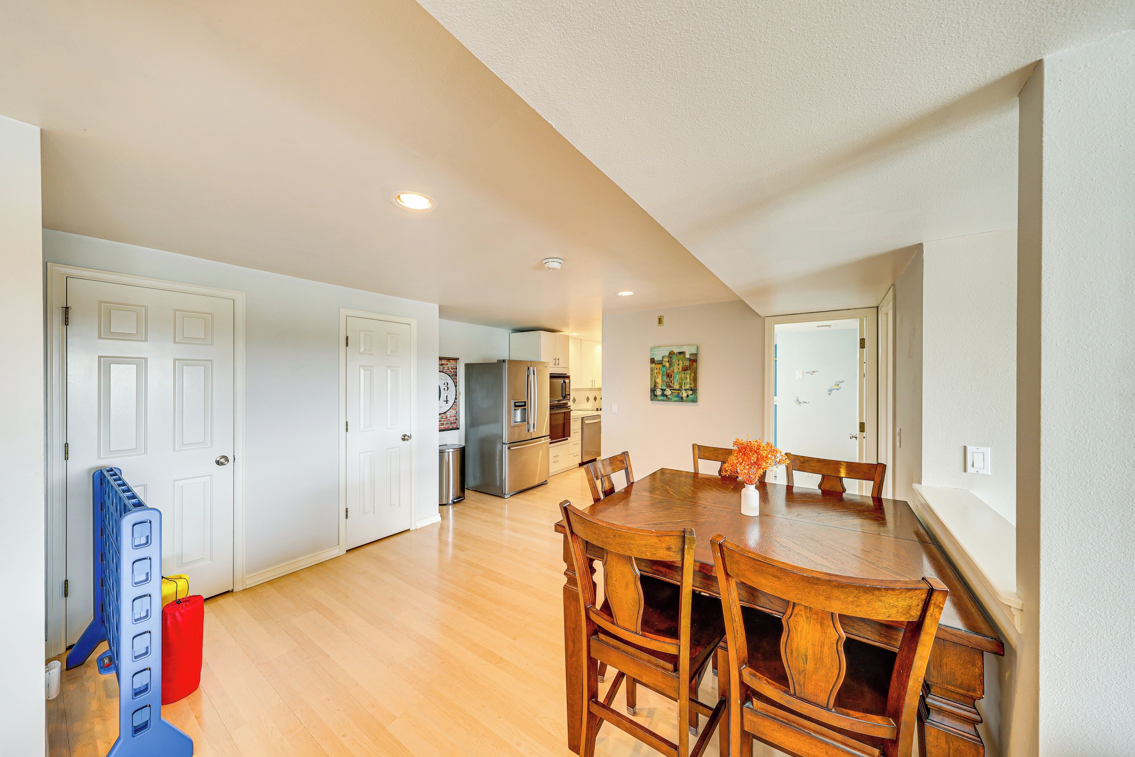 Un comedor amplio con una mesa y sillas de madera, una cocina al fondo y un pasillo que conduce a otras habitaciones.