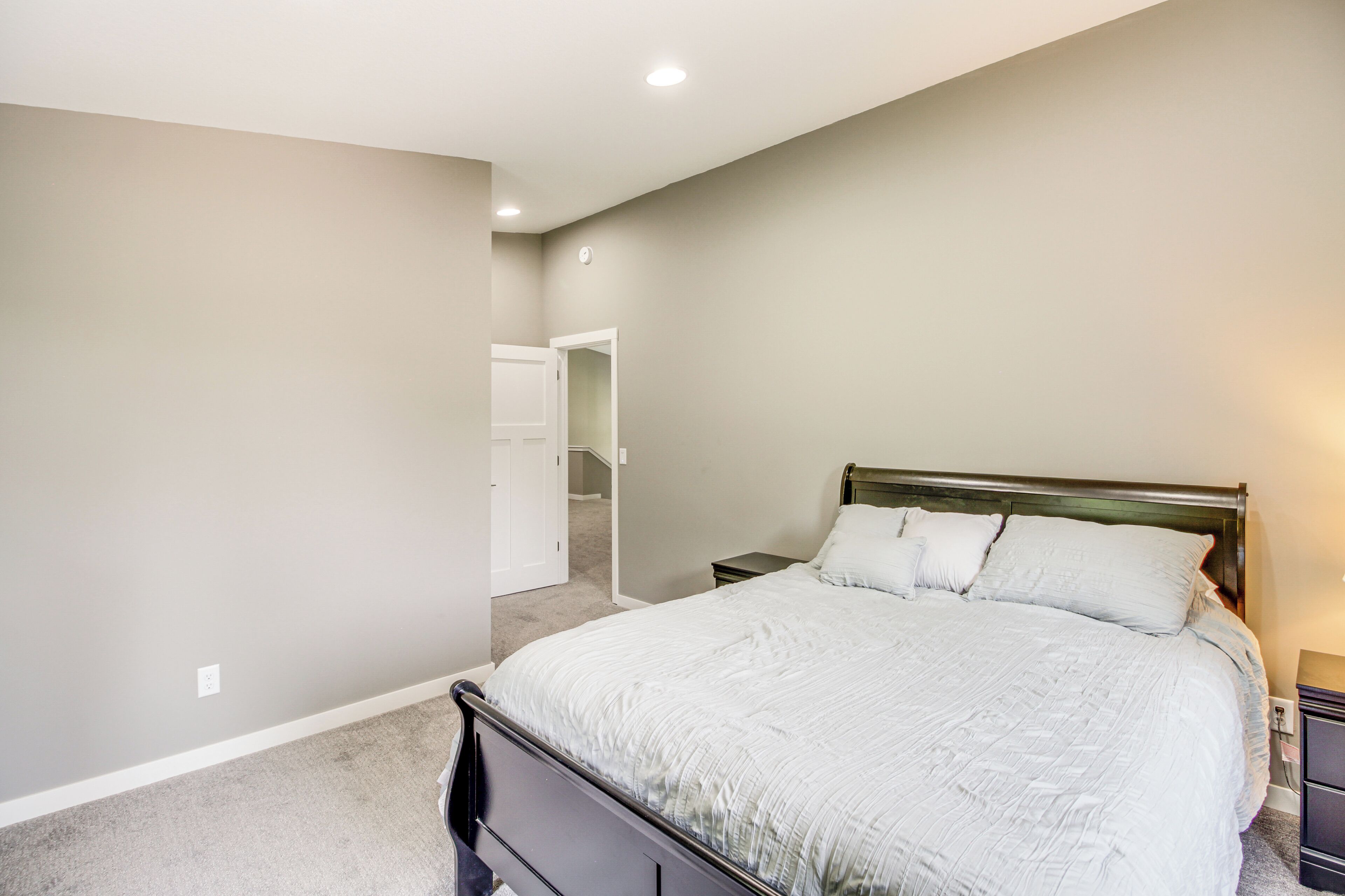 A bedroom with a large bed, a nightstand, and a closet.