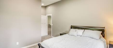 A bedroom with a large bed, a nightstand, and a closet.