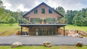 En toetage bindingshus med balkon, omgivet af et naturligt landskab.