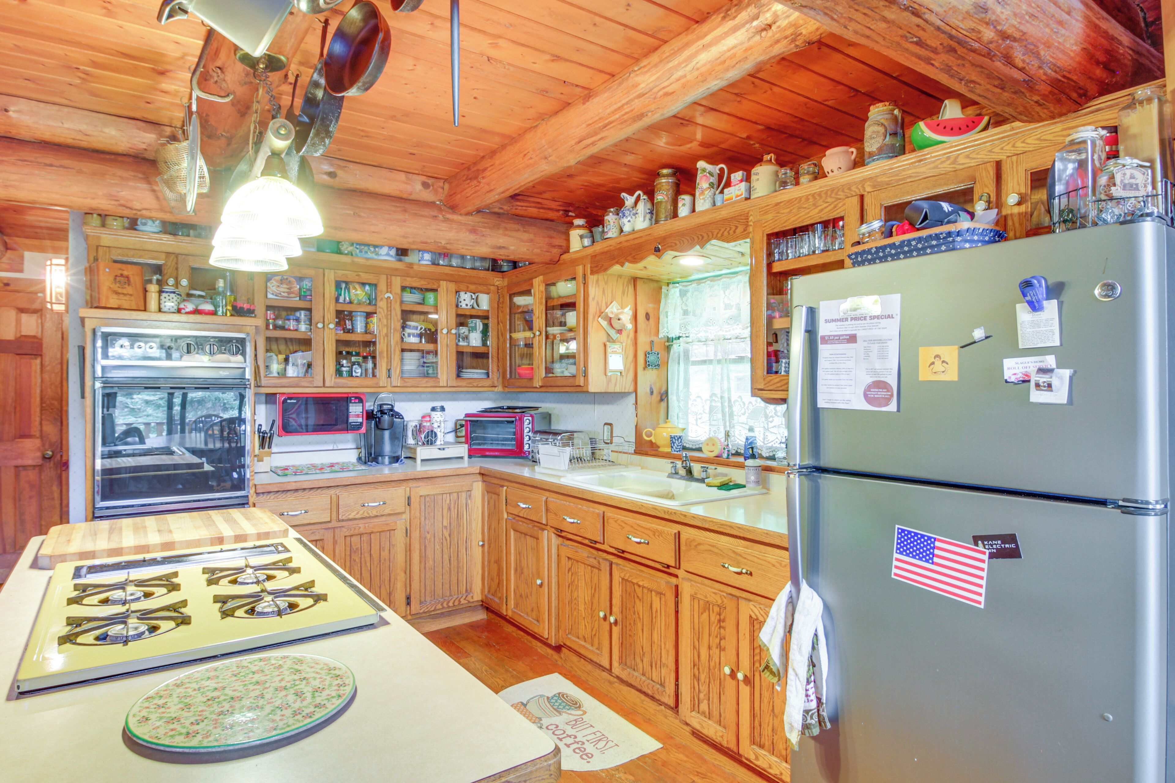 A kitchen with wooden cabinets, a refrigerator, a stove, and various kitchen appliances.