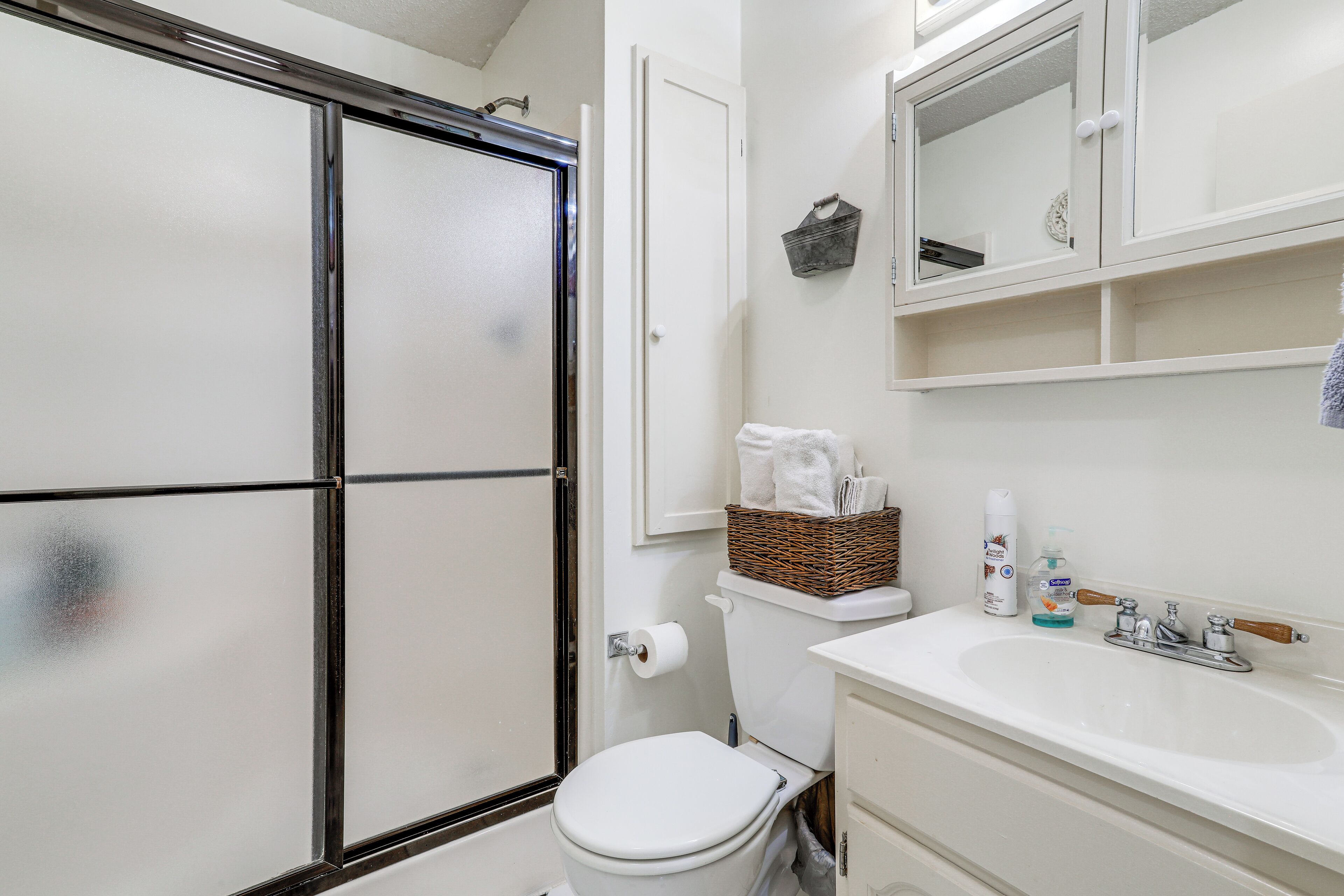 A bathroom with a shower, toilet, and sink.