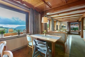 Een eethoek met een houten tafel, stoelen en uitzicht op het buitengebied.