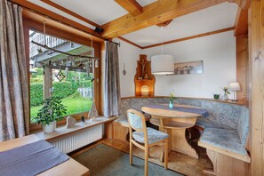 A cozy room with a wooden ceiling, a dining table, a bench, and a window with curtains. - Holiday Apartment '10' with Mountain View, Shared Terrace and Wi-Fi (Todtnau OT Todtnauberg)