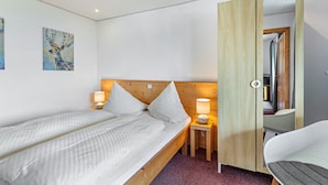 A single bed with a wooden headboard, a bedside table with a lamp, and a chair. - Holiday Apartment '10' with Mountain View, Shared Terrace and Wi-Fi (Todtnau OT Todtnauberg)