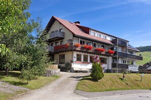 A two-story building with a sloped roof, a balcony with red flowers, and a sign reading 'Fension Birgl.' - Holiday Apartment '10' with Mountain View, Shared Terrace and Wi-Fi (Todtnau OT Todtnauberg)