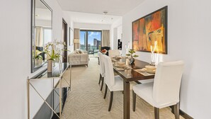 Une chambre d’hôtel moderne avec un coin repas, un grand miroir et une vue sur la ville.
