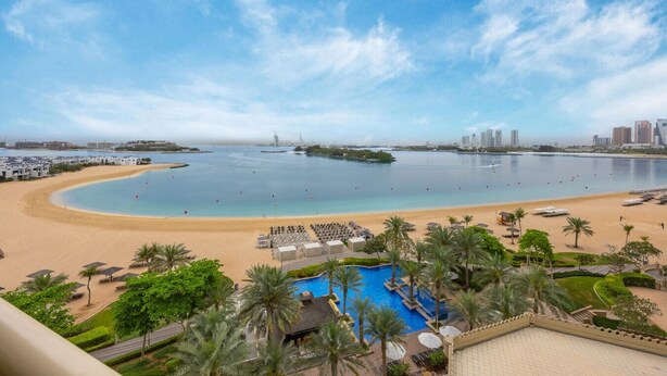 Ein Resort mit Strand, Pool und Blick auf die Stadtlandschaft.