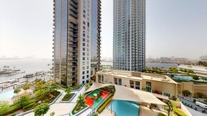 A high-rise residential building with a rooftop pool and marina views.