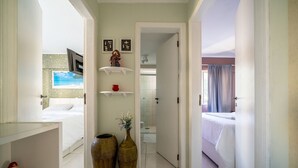 A hotel room with a bed, a small desk, and a bathroom visible through an open door.