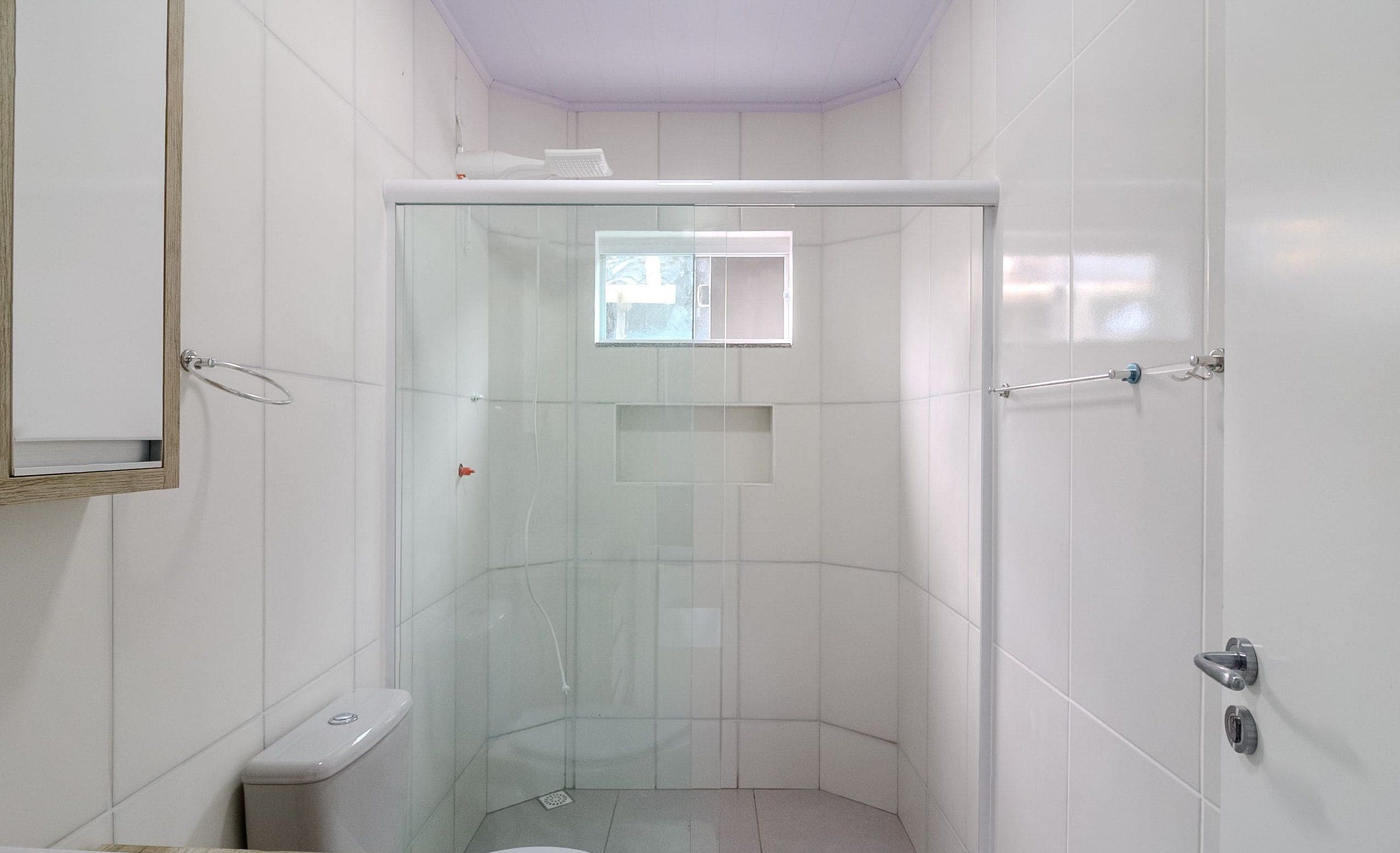 Een moderne badkamer met een douchecabine van glas, een toilet en een wastafel.