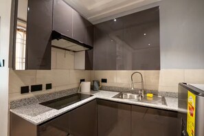 Apartamento conforto, vista para a cidade | Cozinha privada | Frigobar, micro-ondas, talheres/pratos/utensílios de cozinha
