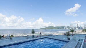 Una piscina en la azotea con vistas a la playa y al horizonte de la ciudad.