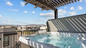 A rooftop hot tub with a clear view of the surrounding buildings and mountains. - St. Gorgeous: Desert Color Lagoon + Beaches (St. George)