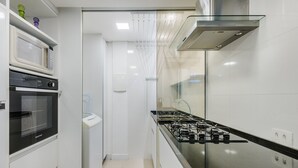A modern kitchen with a built-in oven, microwave, and gas stove.
