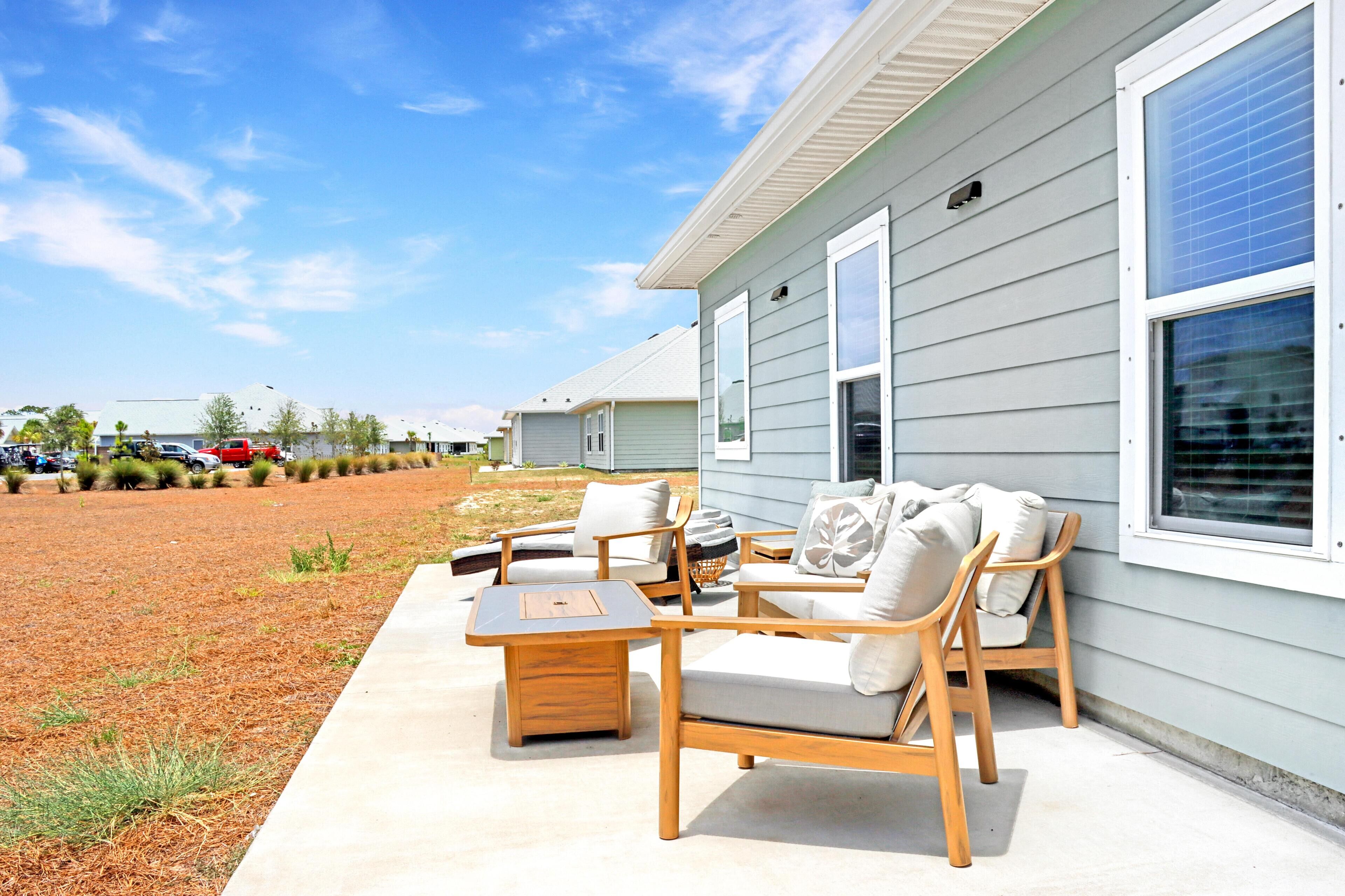 A patio with wooden furniture and a concrete floor.