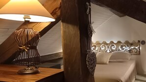A bedroom with a wooden headboard, a bedside lamp, and a bed with a white bedspread.
