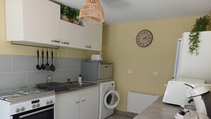 A kitchen with a stove, oven, microwave, and washing machine.