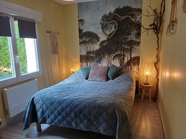 A bedroom with a bed, a window, a wall mural, and two bedside lamps.