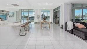 A spacious, modern living area with a kitchen, dining table, and a sofa.