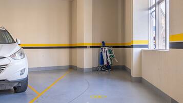 A parking garage with a white car parked in a marked space.