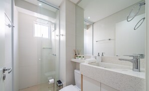 A modern bathroom with a glass shower enclosure, a white sink with a mirror, and a toilet. - Apt w/ Balcony & BBQ 400m From Beach Dbr0805 (Itapema)