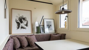 A modern room with a white table, a black lamp, a zebra-patterned sofa, and framed artwork on the wall. - Luxurious, quiet, bright studio in the heart of the south of Pigalle (Paris)